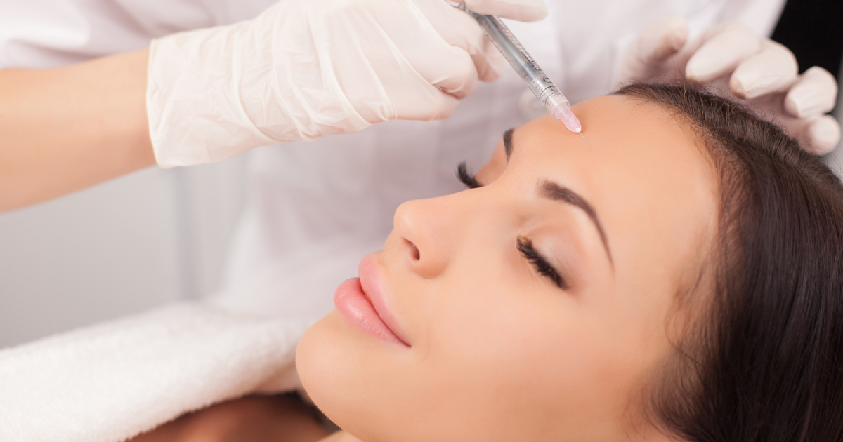 Woman receiving Botox injection on forehead at a clinic in Cornelius, NC