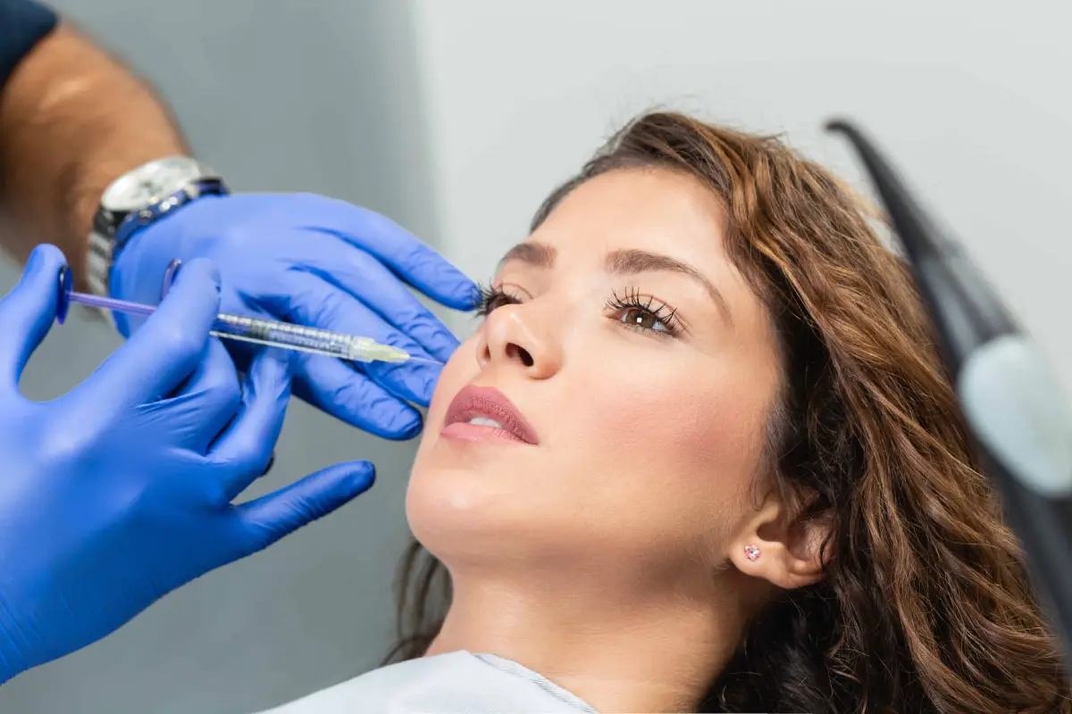 Woman receiving dermal filler injection for smile lines in Cornelius, NC